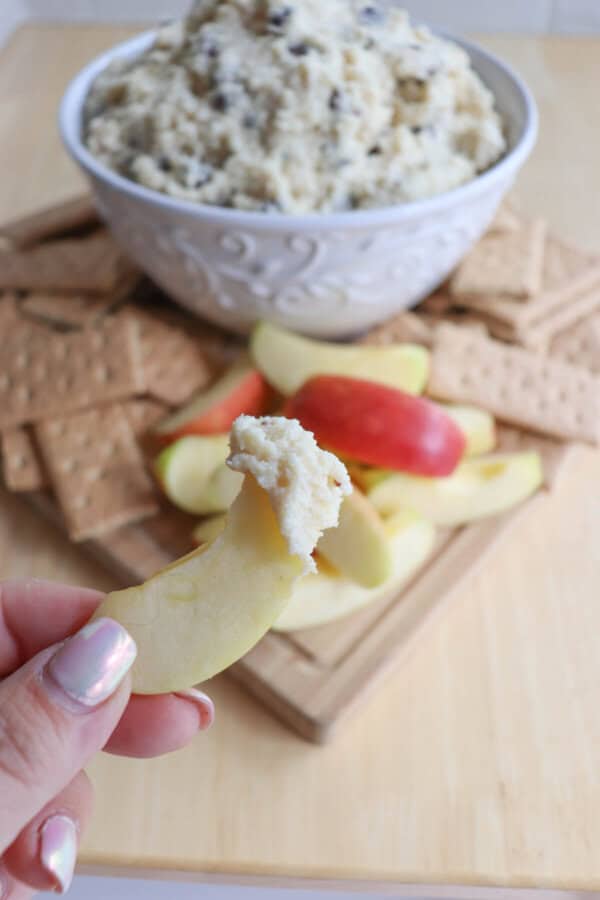 Cottage cheese cookie dough dip in a white bowl surrounded by graham crackers and apple slices.