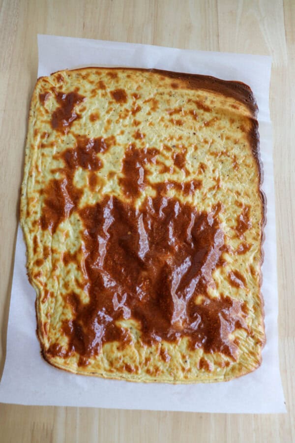 Baked cottage cheese flatbread on a piece of parchment paper.