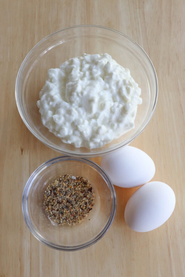 Cottage cheese flatbread ingredients on a wood table.