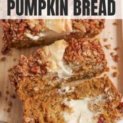 Pumpkin bread, filled with cream cheese with a strussel topping, cut into slices on a wooden board.