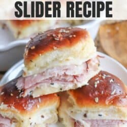 Three Ham & Swiss Sliders stacked on a a white plate.