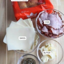 Ingredients for Ham & Swiss Sliders in clear glass bowls o a wooden table.