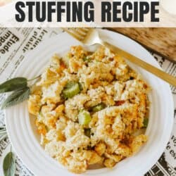 Cornbread stuffing with bread cubes, diced celery and onion bits on a white plate with a gold fork.