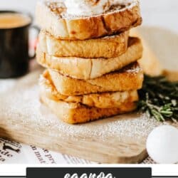A stack of eggnog French toast topped with whipped cream and powdered sugar on a wooden board. A cup of coffee is in the background. The text eggnog French toast and homemadeheather.com is at the bottom.