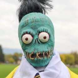 Zombie shrunken head that looks like Bob from Beetlejuice with a white dress shirt and yellow suit.