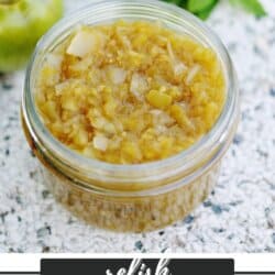 Green tomato relish in a clear glass jar.