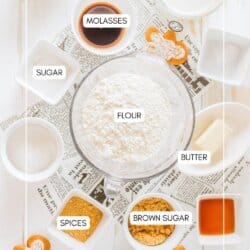 Ingredients for gingerbread pancakes in clear glass bowls on a newspaper lined table.