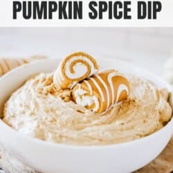 Creamy pumpkin spice dip in a white bowl topped with Little Debbie pumpkin rolls on a newspaper lined table.