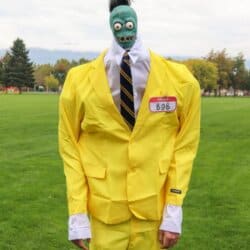 Zombie shrunken head that looks like Bob from Beetlejuice with a white dress shirt and yellow suit.