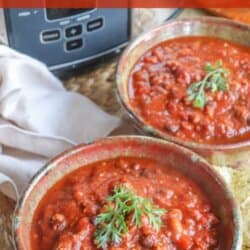 A bowl of chili garnished with a sprig of parsley, placed on a table with a second bowl partially visible. The text Crockpot Chili Recipe is overlaid at the top. The website homemadeheather.com is at the bottom.