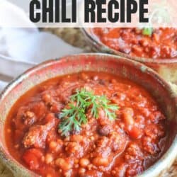 A bowl of chili garnished with a sprig of parsley, placed on a table with a second bowl partially visible. The text Crockpot Chili Recipe is overlaid at the top. The website homemadeheather.com is at the bottom.