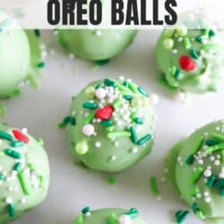 Green Grinch Oreo Balls covered in festive sprinkles with a red candy heart.