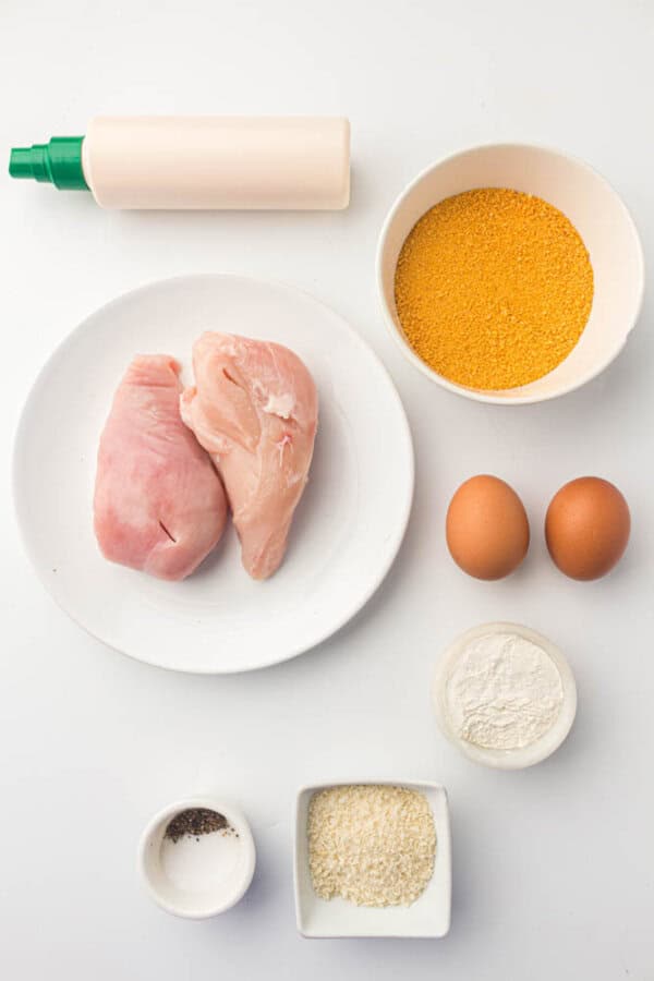 Chicken cutlet ingredients on a white surface.