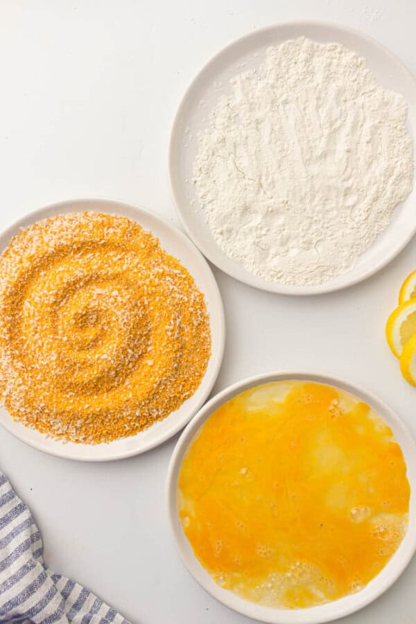 Egg, flour and breadcrumbs on plates.