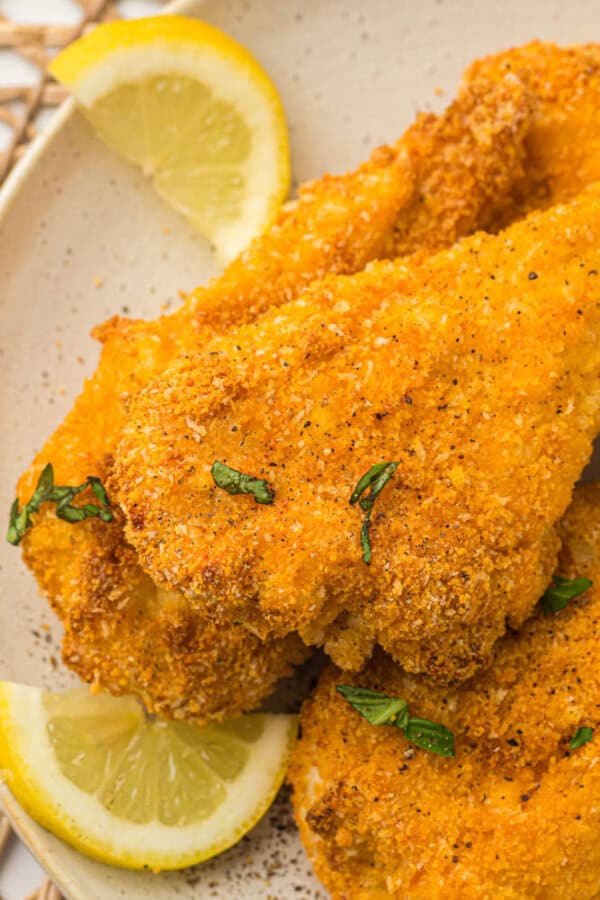 Breaded chicken strips on a white plate.