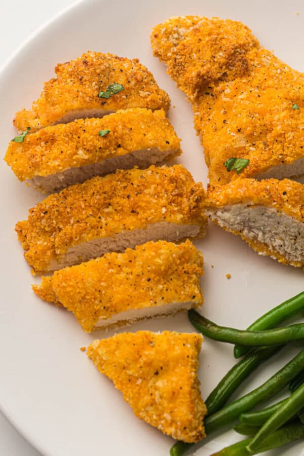 Breaded chicken tenders on a white plate.