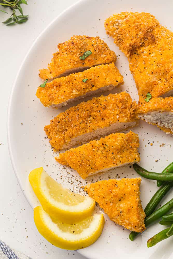 Breaded chicken strips on a white plate.