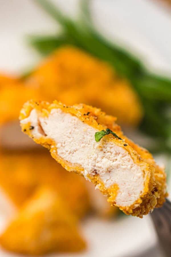 Breaded chicken strip on a fork.