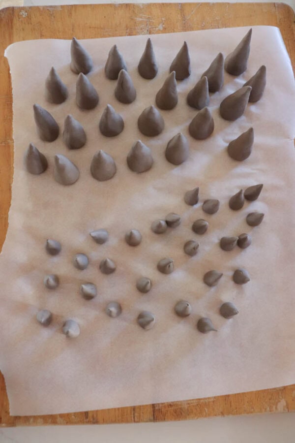 Many clay teeth on a piece of parchment paper.