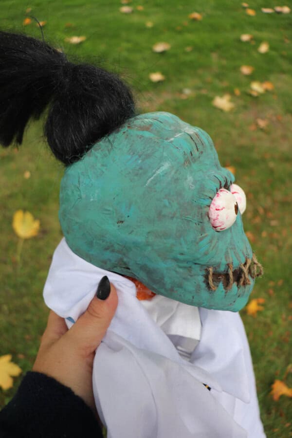 Zombie shrunken head that looks like Bob from Beetlejuice in a turquoise color.