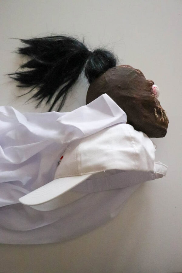 plague doctor costume Zombie shrunken head that looks like Bob from Beetlejuice glued to the top of a white hat.
