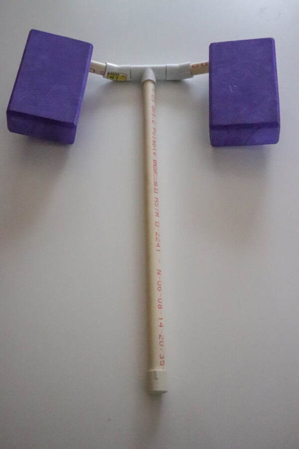 plague doctor costume White tubing and purple yoga blocks on a white table.