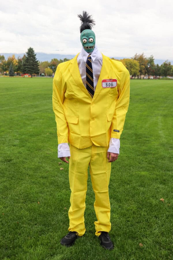 Zombie shrunken head that looks like Bob from Beetlejuice with a white dress shirt and yellow suit.