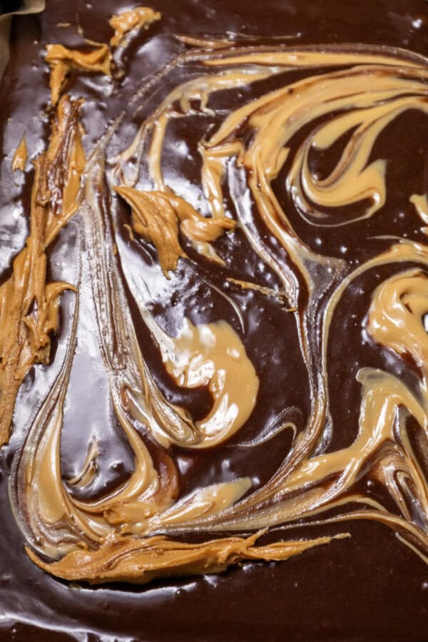 Brownie batter on a parchment paper lined baking sheet.