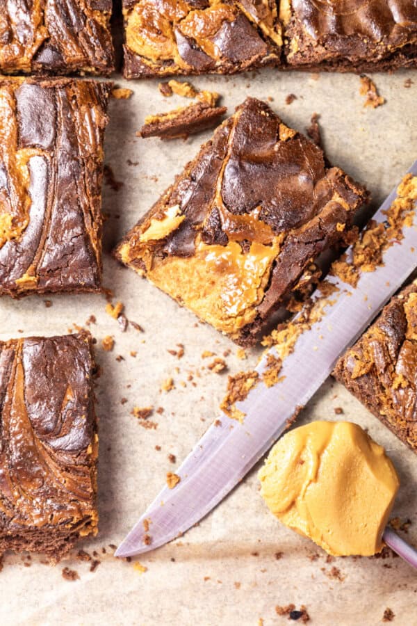 Peanut Butter Brownies on parchment paper with a butter knife.