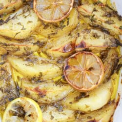 Lemon greek potatoes in a white casserole dish.