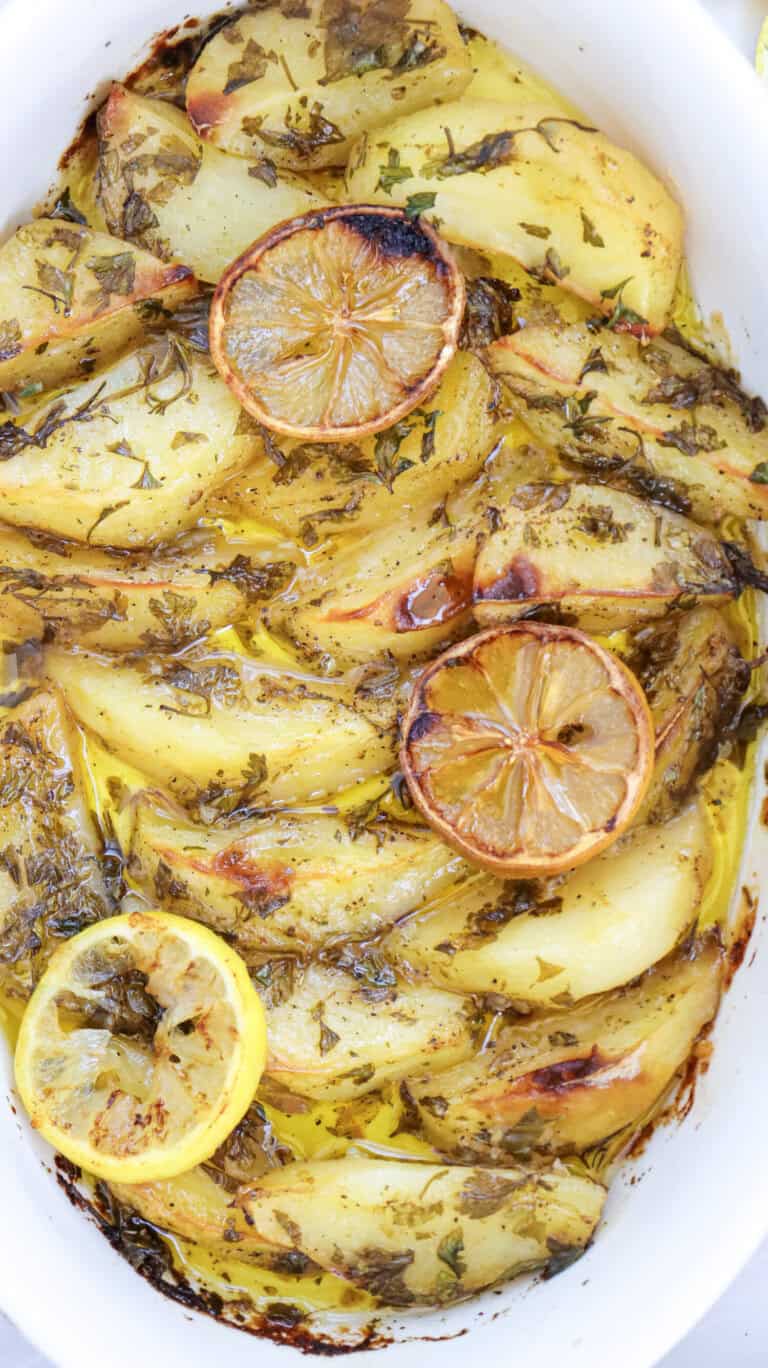 Lemon greek potatoes in a white casserole dish.