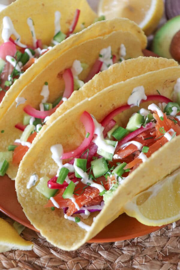 Corn tortillas filled with smoked salmon, diced cucumber and pickled red pepper topped with crema.