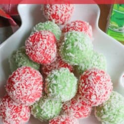 A festive plate of Christmas jello balls, adorned with red and green coconut flakes, is artfully displayed alongside a hint of thin mint cookie charm. The background features holiday-themed decorations and a chevron-patterned red and white napkin.