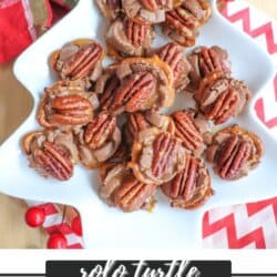 A festive tree-shaped platter holds pretzel snacks topped with melted chocolate, caramel, and pecans. The background features red berries, a plaid cloth, and a candy packaging. Text reads: Rolo Turtle Pretzel Recipe from homemadeheather.com.
