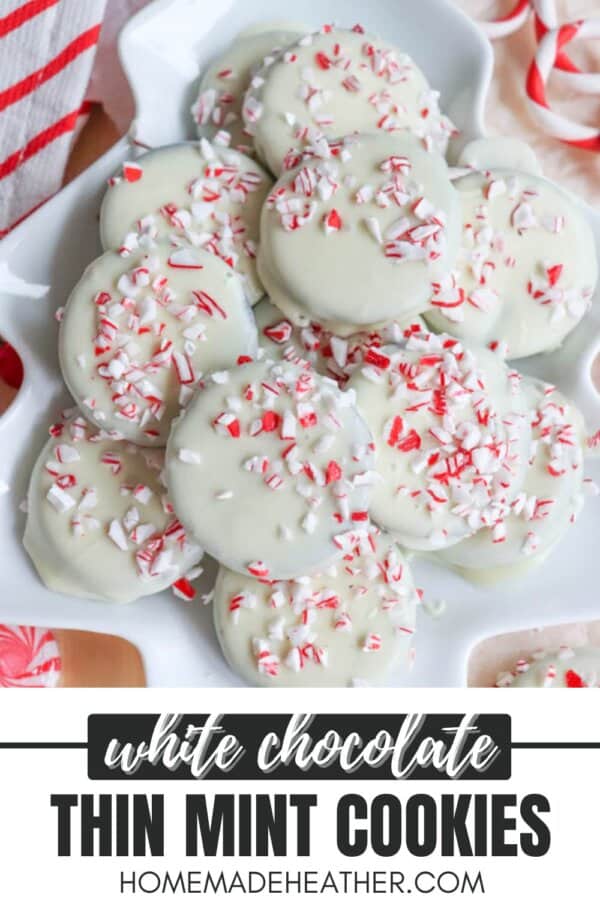 A plate of thin mint cookies, crafted from a cherished recipe, is coated in white chocolate and sprinkled with crushed peppermint candy. They rest on a festive background with red and white accents. Text overlay reads White Chocolate Thin Mint Cookies HomemadeHeather.com.