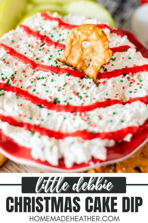 A festive bowl of Christmas cake dip topped with red icing, green and red sprinkles, and a pretzel piece on a red plate. The text reads Little Debbie Christmas Cake Dip and homemadeheather.com.