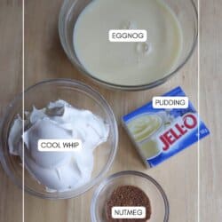 Ingredients for a dessert on a wooden table: a bowl of eggnog, a bowl of Cool Whip, a small bowl of nutmeg, and a box of Jell-O pudding mix.