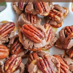 A plate of Rolo turtle pretzels topped with pecans. The treats are a mix of chocolate, caramel, and pretzels, arranged on a white dish. A website URL is visible at the bottom.