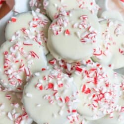 A plate of white chocolate thin mint cookies topped with crushed candy canes. The text reads White Chocolate Thin Mint Cookie Recipe and homemadeheather.com on a red banner.