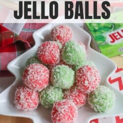 Festive red and green jello balls, reminiscent of a thin mint cookie recipe, are covered in coconut and arranged in a tree-shaped dish. The background includes red and white holiday-themed decorations and a box of jello mix.