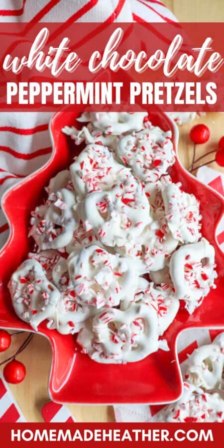 A festive red plate piled with white chocolate peppermint pretzels, sprinkled with crushed peppermint candy. The plate is shaped like a Christmas tree and is surrounded by red berries and a striped red and white cloth.