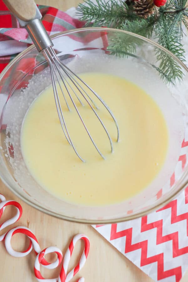 Eggnog and instant pudding mixed together in a glass bowl.