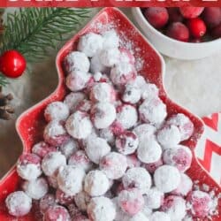 A red tree-shaped dish brimming with sugared cranberries graces a festive table adorned with pine branches and a bowl of fresh cranberries. The text reads "Cranberry Candy Recipe" from homemadeheather.com, celebrating the perfect holiday treat.
