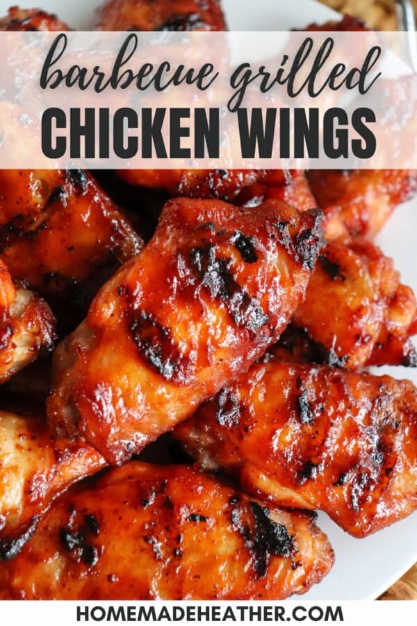 Close-up of barbecue grilled chicken wings, glistening with a charred, caramelized glaze. The texture appears crispy and flavorful, with visible grill marks.