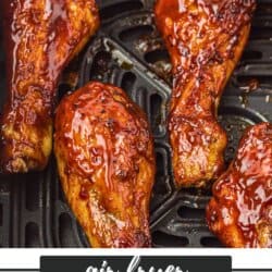Close-up of four glistening BBQ chicken drumsticks, freshly air-fried on a grill tray. Text at the bottom reads air fryer BBQ chicken homemadeheather.com.