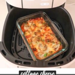 A glass dish with baked cottage cheese pizza bowl sits inside an air fryer. The pizza has browned cheese, mushrooms, and green peppers. The text at the bottom of the image reads, Cottage Cheese Pizza Bowls, with a website URL below.