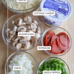 Ingredients for a pizza or casserole are laid out in bowls: shredded cheese, mushrooms, diced onions, sliced pepperoni, cubed green peppers, cottage cheese, and sauce. Each ingredient is labeled.