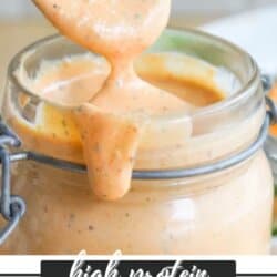 Close-up of a jar filled with creamy, orange Big Mac sauce. A spoon is lifting out some sauce, and a bit drips down the side of the jar. Text reads: high protein Big Mac sauce with a website link below.