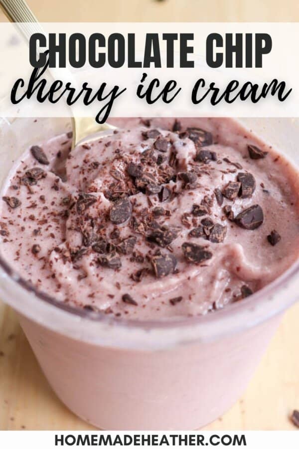 A close-up of chocolate chip cherry ice cream in a clear cup, topped with chocolate chunks. A spoon is placed in the ice cream. Text on the image reads Chocolate Chip Cherry Ice Cream and homemadeheather.com.