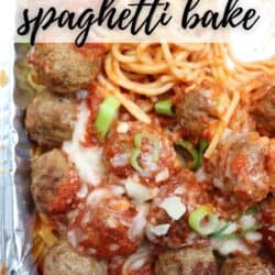 A close-up of a spaghetti bake in a foil tray. The dish features spaghetti noodles, meatballs, marinara sauce, and melted cheese, topped with chopped green onions. Text overlay reads, Camping Recipe: Spaghetti Bake. At the bottom is homemadeheather.com.